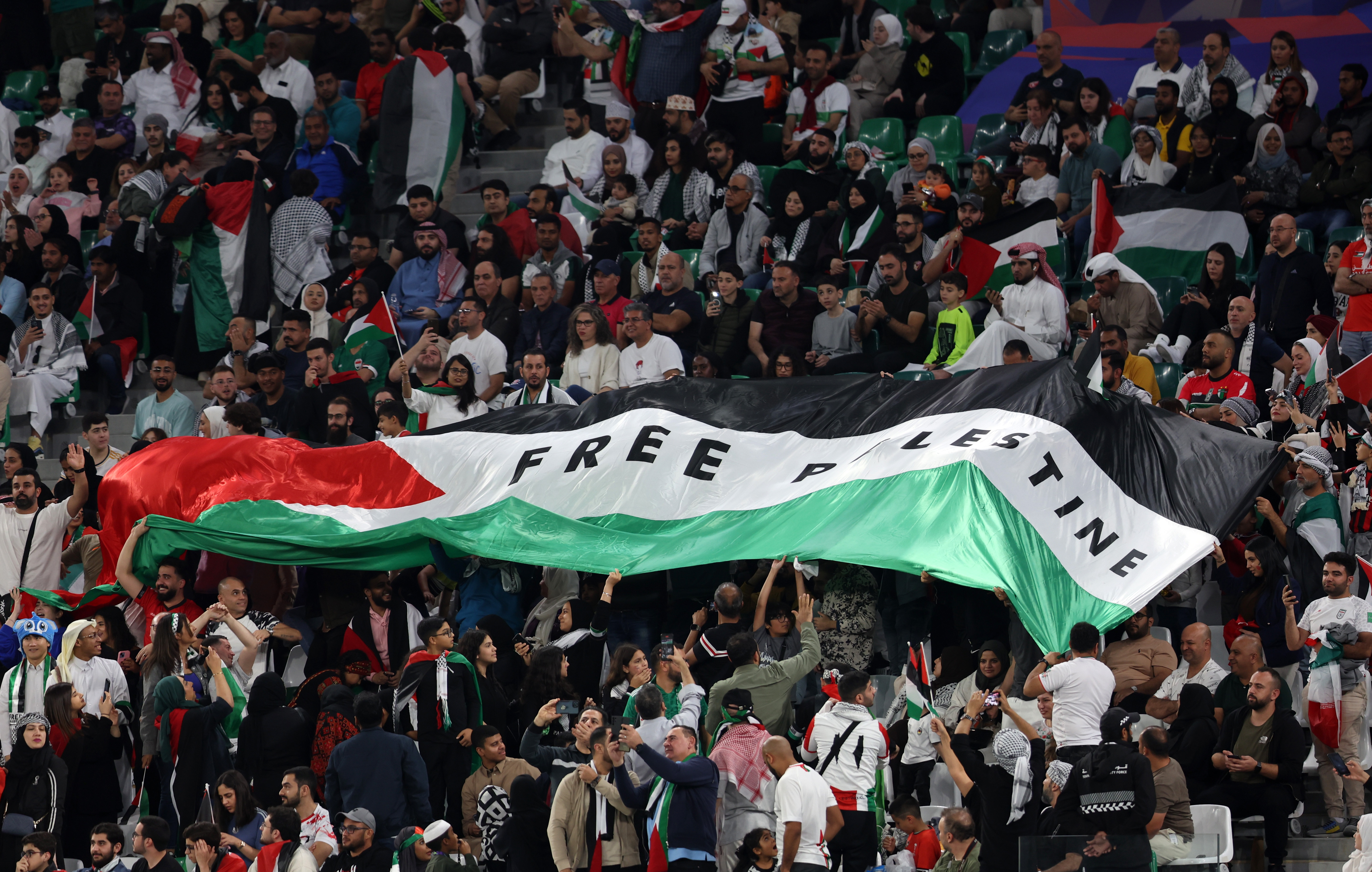 جماهير منتخب فلسطين رفعت علم البلاد على مدرجات ملعب المدينة التعليمية خلال مباراة إيران (winwin)