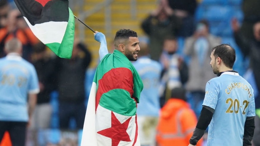 الجزائري رياض محرز يحمل علم فلسطين خلال احتفالات سيتي بلقب الدوري الإنجليزي 2022 (Getty) ون ون winwin