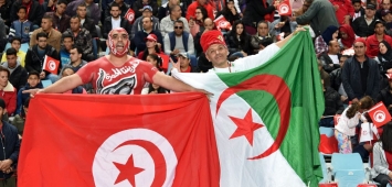 مشجعان يرفعان العلمين التونسي والجزائري