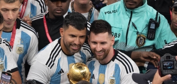 ليونيل ميسي وسيرخيو أغويرو مع مجسم كأس العالم (Getty)