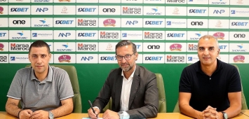 المدرب الألماني جوزيف زينباور (وسط) خلال توقيع عقده مع الرجاء (twitter/RCAofficiel)