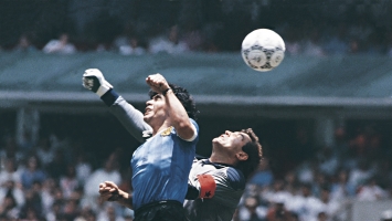 أرشيفية- استخدام مارادونا يده ليسجل الهدف الأول للأرجنتين خلال مباراة ربع نهائي كأس العالم 1986 أمام إنجلترا (Getty) ون ون winwin 